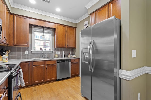 kitchen with appliances with stainless steel finishes, decorative backsplash, sink, light hardwood / wood-style floors, and crown molding