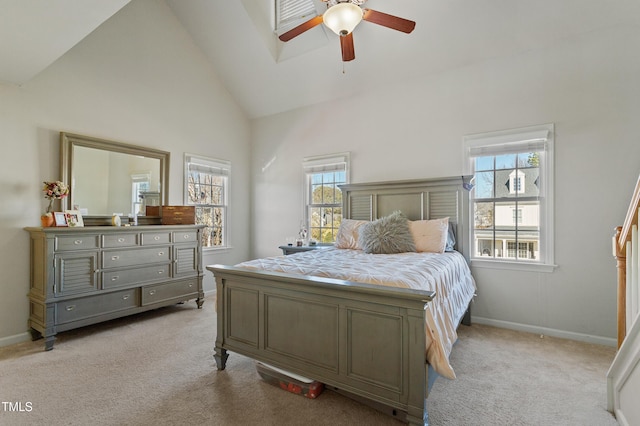 bedroom featuring ceiling fan, multiple windows, light colored carpet, and high vaulted ceiling