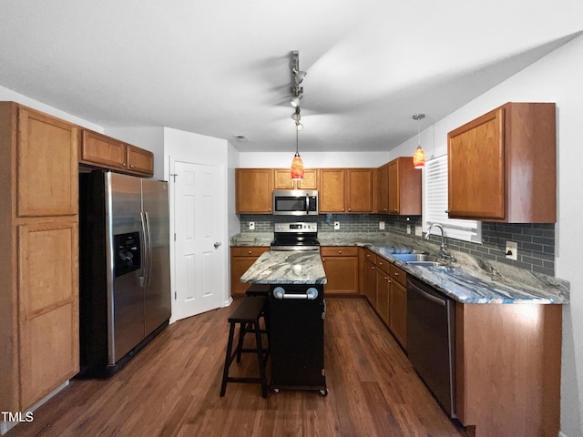 kitchen with stainless steel appliances, dark hardwood / wood-style floors, sink, hanging light fixtures, and a center island