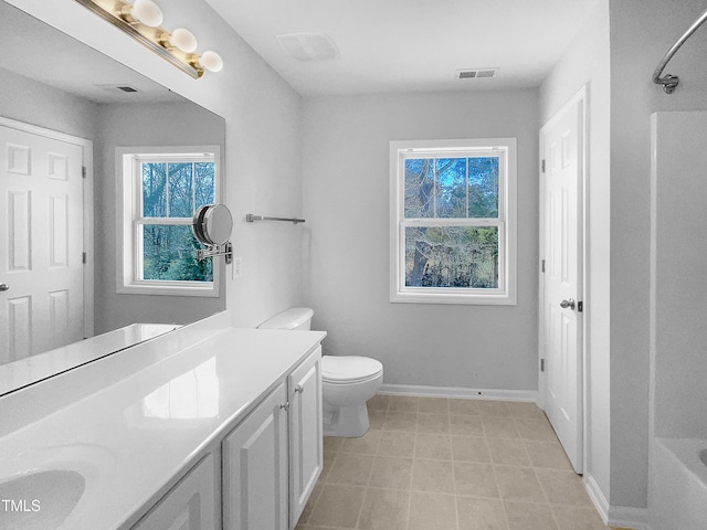 bathroom with toilet, plenty of natural light, and vanity