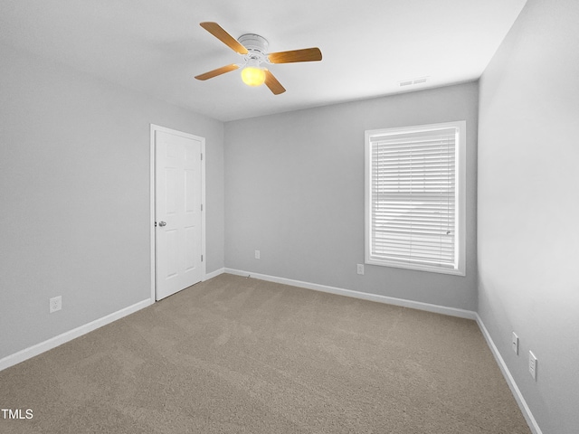 carpeted spare room featuring ceiling fan