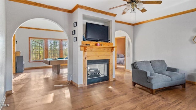 living room with ceiling fan, crown molding, and hardwood / wood-style flooring