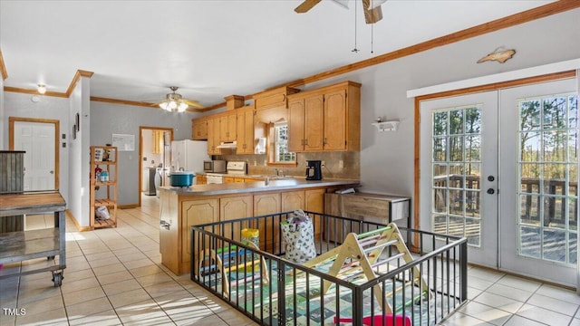 kitchen with light tile patterned floors, ornamental molding, kitchen peninsula, and french doors