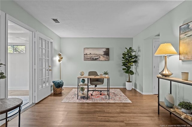 office space featuring french doors, visible vents, baseboards, and wood finished floors