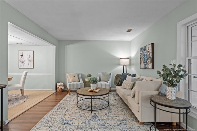 living area with visible vents, baseboards, and wood finished floors