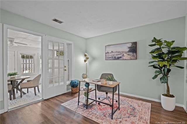 office area featuring ceiling fan, dark wood-style flooring, visible vents, and baseboards