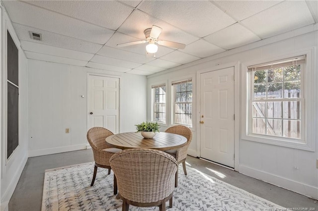 dining room featuring a paneled ceiling, baseboards, visible vents, and concrete flooring