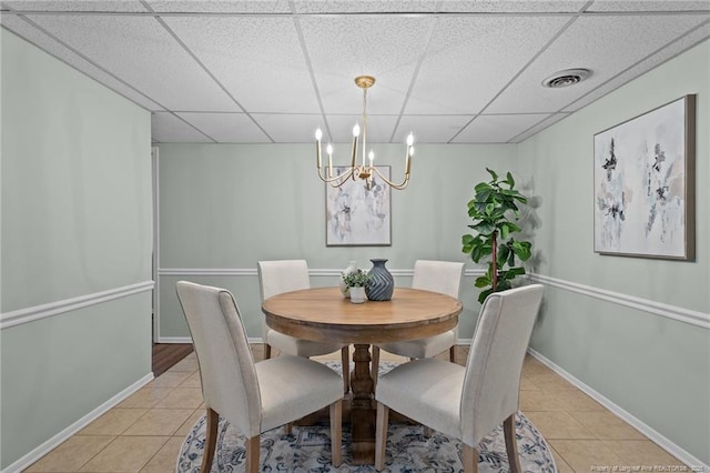 dining room with light tile patterned floors, a drop ceiling, visible vents, baseboards, and an inviting chandelier