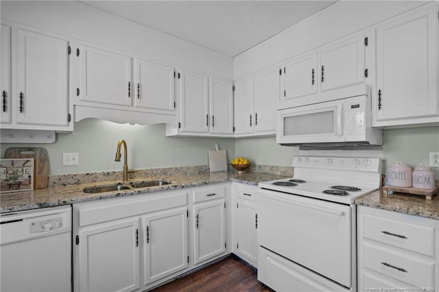 kitchen with light stone counters, white appliances, a sink, and white cabinetry