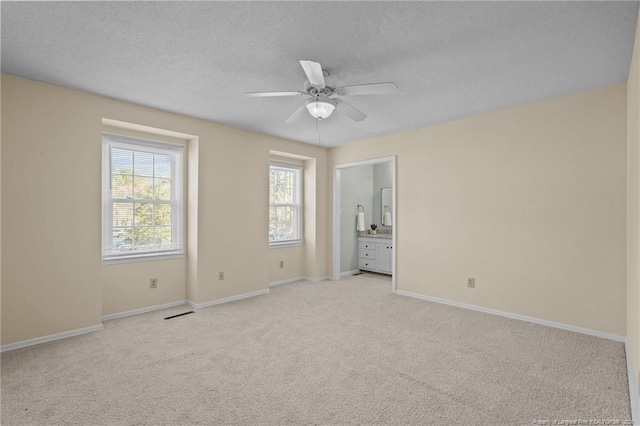 unfurnished room featuring light carpet, a textured ceiling, a ceiling fan, and baseboards