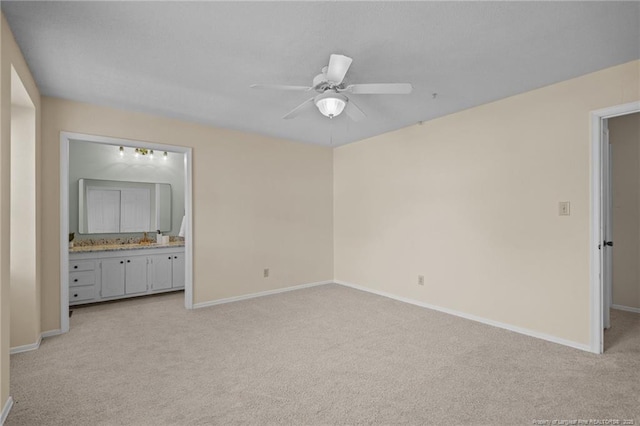 unfurnished bedroom featuring a ceiling fan, light carpet, baseboards, and ensuite bathroom