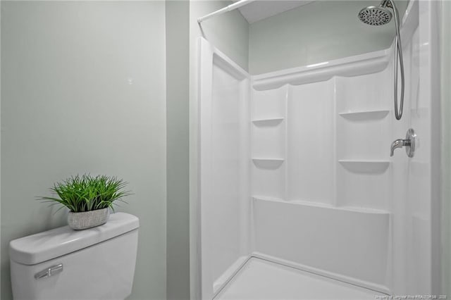 bathroom with a shower stall and toilet