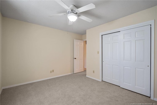 unfurnished bedroom featuring carpet floors, a closet, a ceiling fan, and baseboards