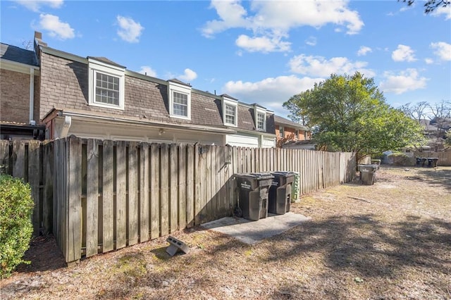 exterior space featuring roof with shingles and fence