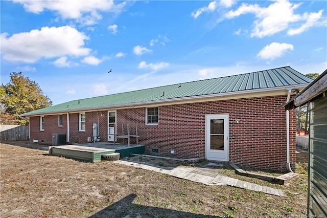 rear view of property featuring brick siding, crawl space, metal roof, cooling unit, and a wooden deck