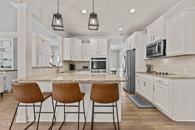 kitchen with stainless steel appliances, white cabinetry, sink, and kitchen peninsula