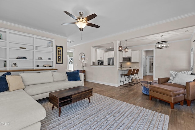 living room with ceiling fan, ornamental molding, and dark hardwood / wood-style flooring