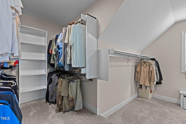 walk in closet featuring lofted ceiling and light carpet