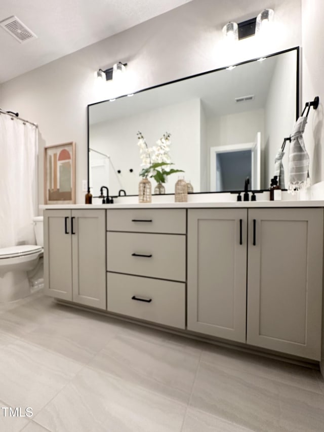 bathroom featuring toilet, vanity, and curtained shower