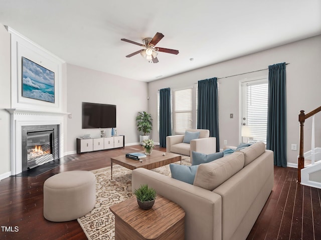 living room featuring ceiling fan and dark hardwood / wood-style floors