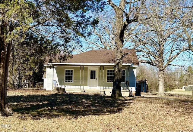 back of property with a porch and a yard