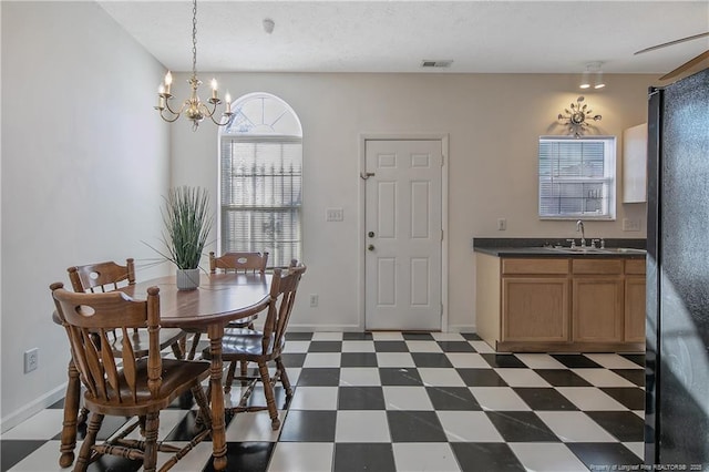 dining area with sink and a notable chandelier