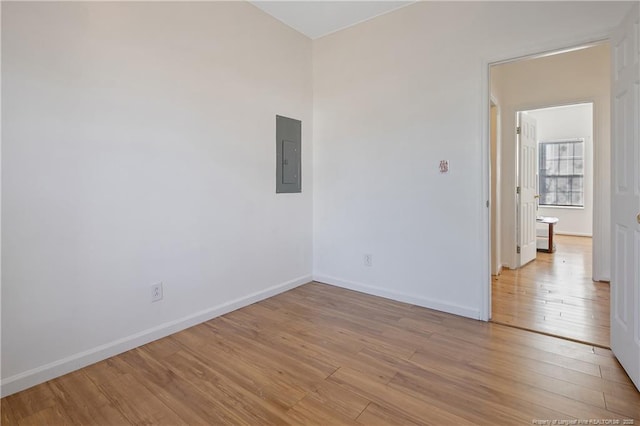 empty room with light wood-type flooring and electric panel