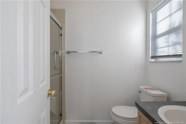 bathroom featuring a shower with door, a wealth of natural light, and vanity