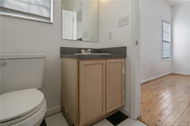 bathroom with toilet, hardwood / wood-style flooring, and vanity