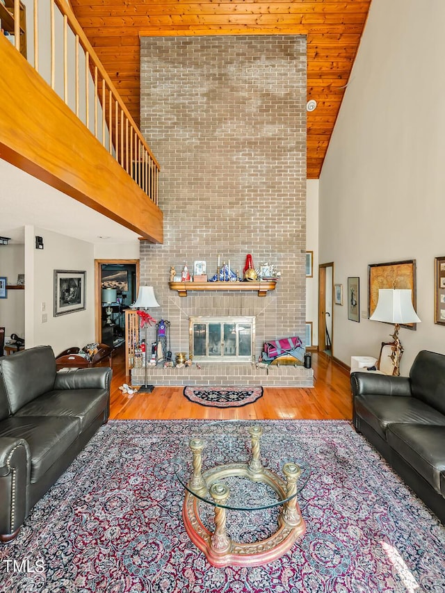 living room featuring wooden ceiling, a fireplace, hardwood / wood-style floors, and high vaulted ceiling