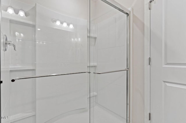 bathroom with a shower with door