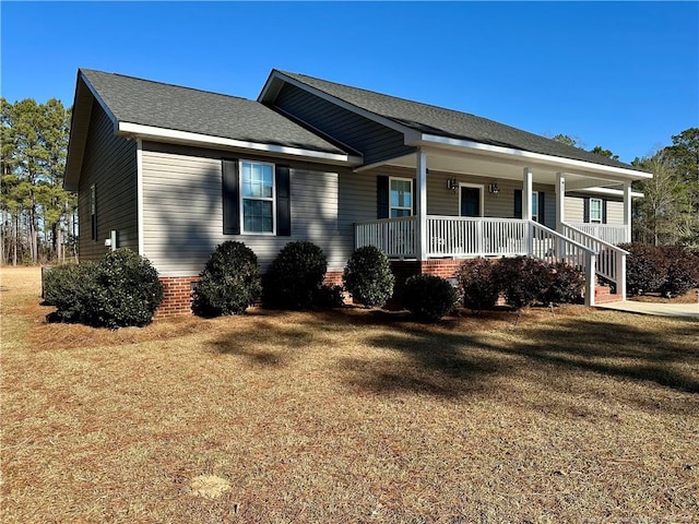 ranch-style home featuring a front yard and covered porch