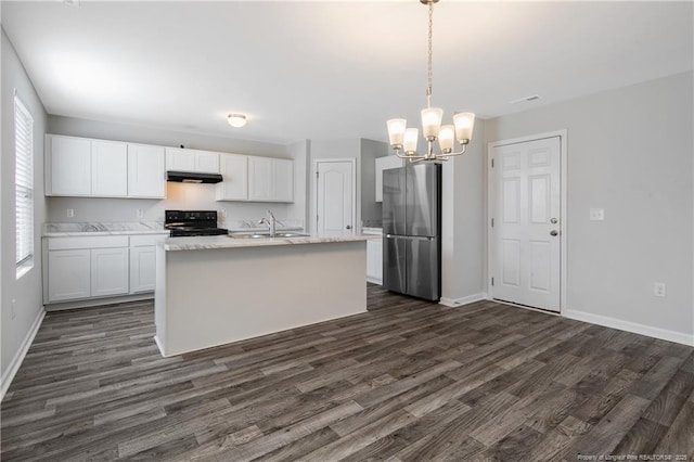 kitchen featuring decorative light fixtures, black range with electric cooktop, stainless steel refrigerator, and white cabinetry