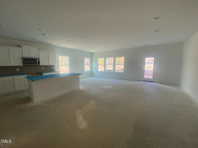 kitchen featuring white cabinets, tasteful backsplash, and a center island