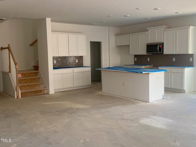 kitchen featuring white cabinetry, tasteful backsplash, and a center island