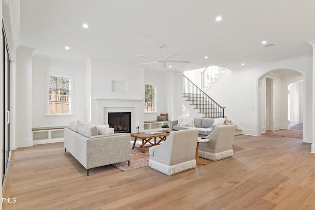 living room featuring ceiling fan, ornamental molding, and light hardwood / wood-style floors