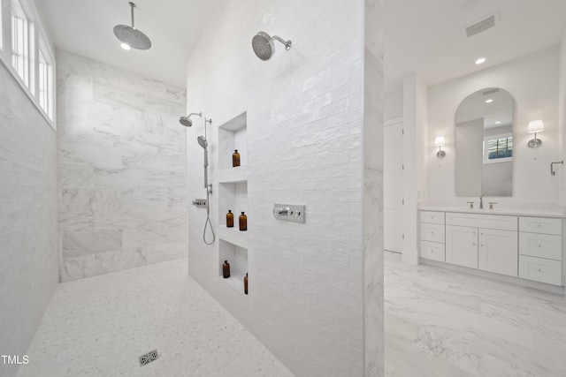 bathroom featuring vanity and tiled shower