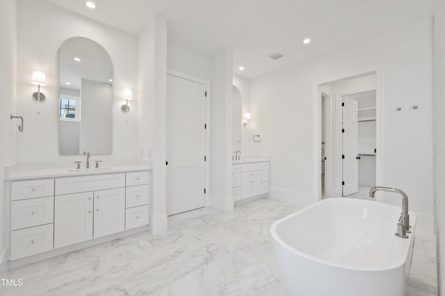 bathroom with a washtub and vanity