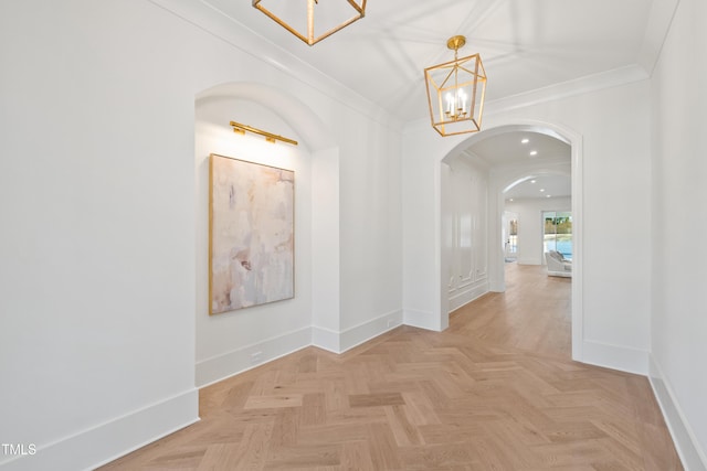 hallway featuring light parquet floors, a chandelier, and crown molding