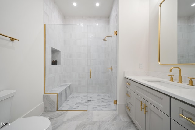 bathroom with toilet, vanity, and an enclosed shower