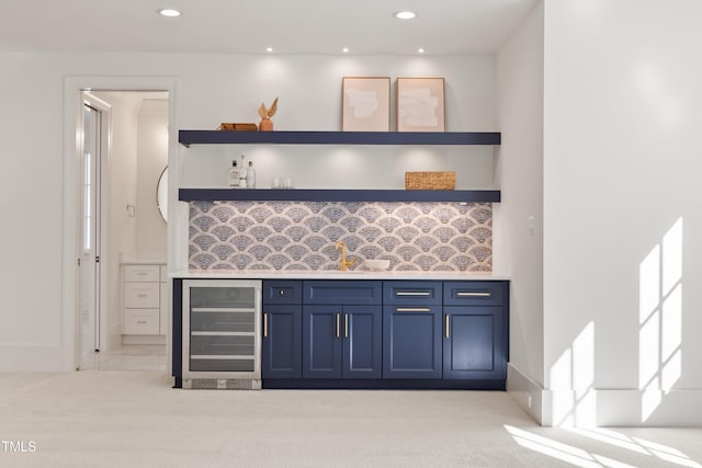 kitchen with light colored carpet, wine cooler, blue cabinets, and sink