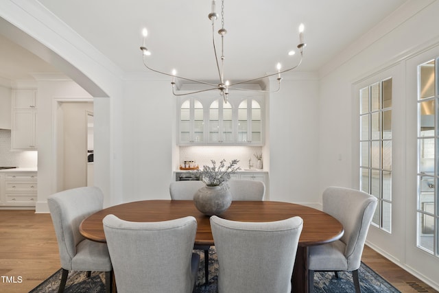 dining area featuring light wood-type flooring and crown molding