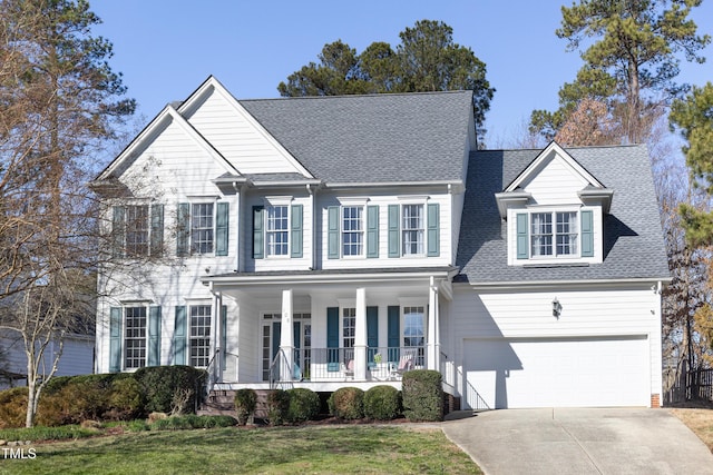 view of front of property with a front yard, a garage, and a porch