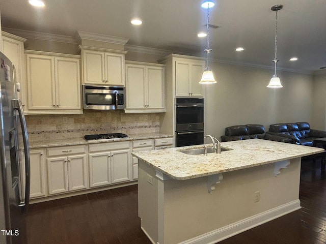 kitchen with decorative light fixtures, tasteful backsplash, dark hardwood / wood-style floors, a center island with sink, and stainless steel appliances