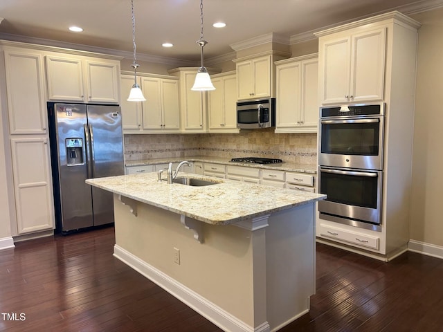 kitchen featuring a center island with sink, stainless steel appliances, backsplash, pendant lighting, and sink