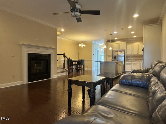 living room with ornamental molding, ceiling fan with notable chandelier, and dark hardwood / wood-style floors