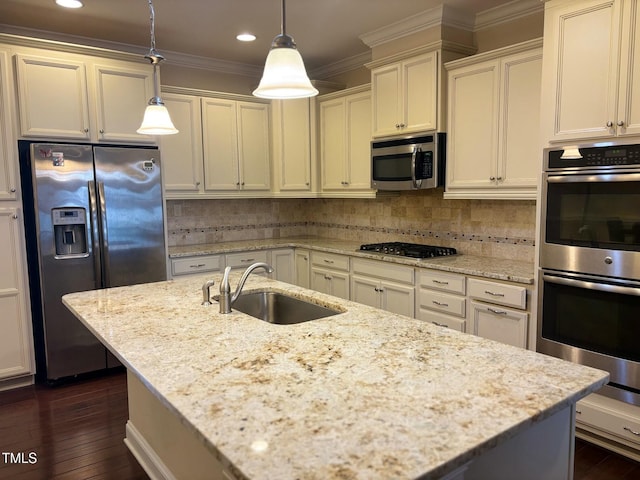 kitchen featuring hanging light fixtures, light stone countertops, appliances with stainless steel finishes, and sink