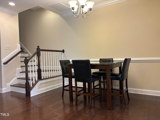 dining room featuring dark hardwood / wood-style flooring, ornamental molding, and an inviting chandelier