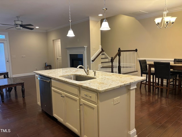 kitchen with stainless steel dishwasher, a center island with sink, hanging light fixtures, and sink