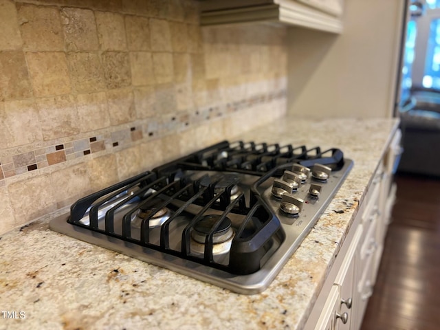 room details featuring light stone countertops and stainless steel gas stovetop